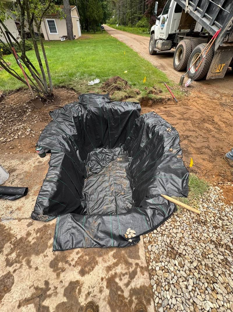 Drain pit lined with landscape fabric before the pea stone goes in