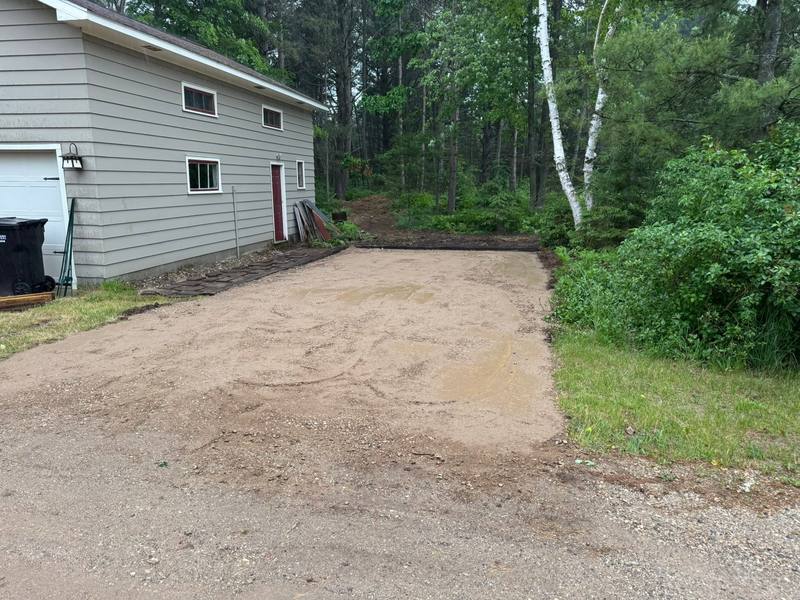 After: graded pad beside the garage, prepped for gravel